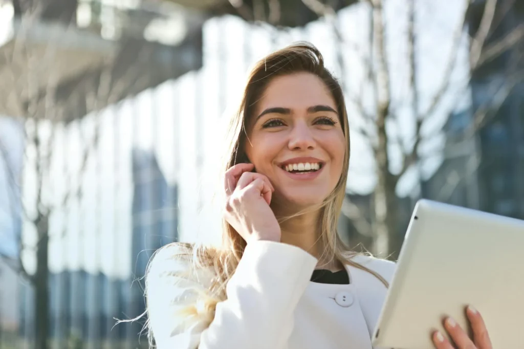 Woman using tablet and phone outdoors.