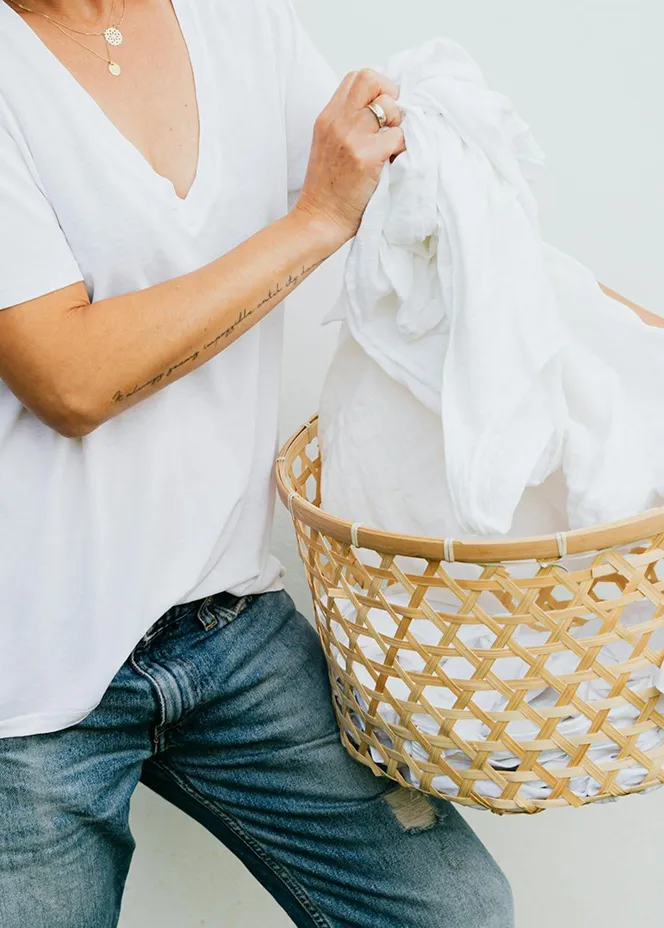 Person holding laundry basket with linens