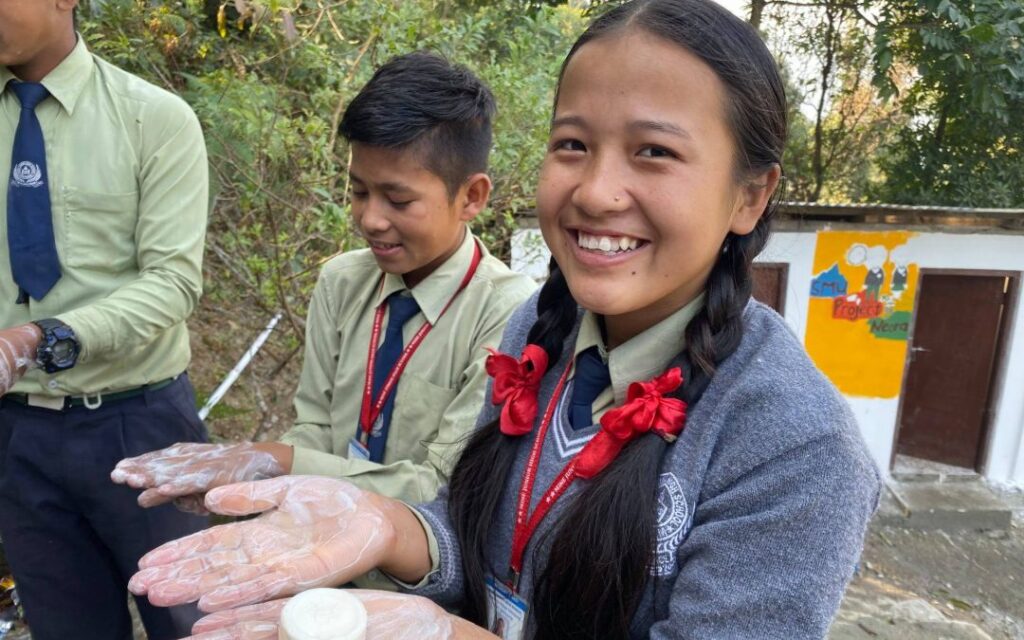 Children demonstrating handwashing outdoors in Asia fighting COVID19 for Project Neora IX.