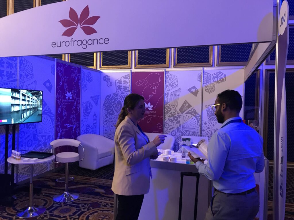 Two people discussing at a Eurofragance fair booth.