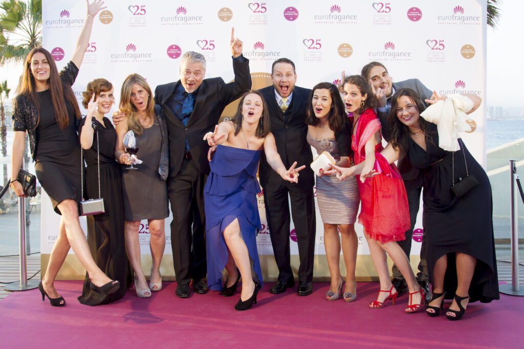 Group of Eurofragance perfumers team celebrating at a formal event's photocall.