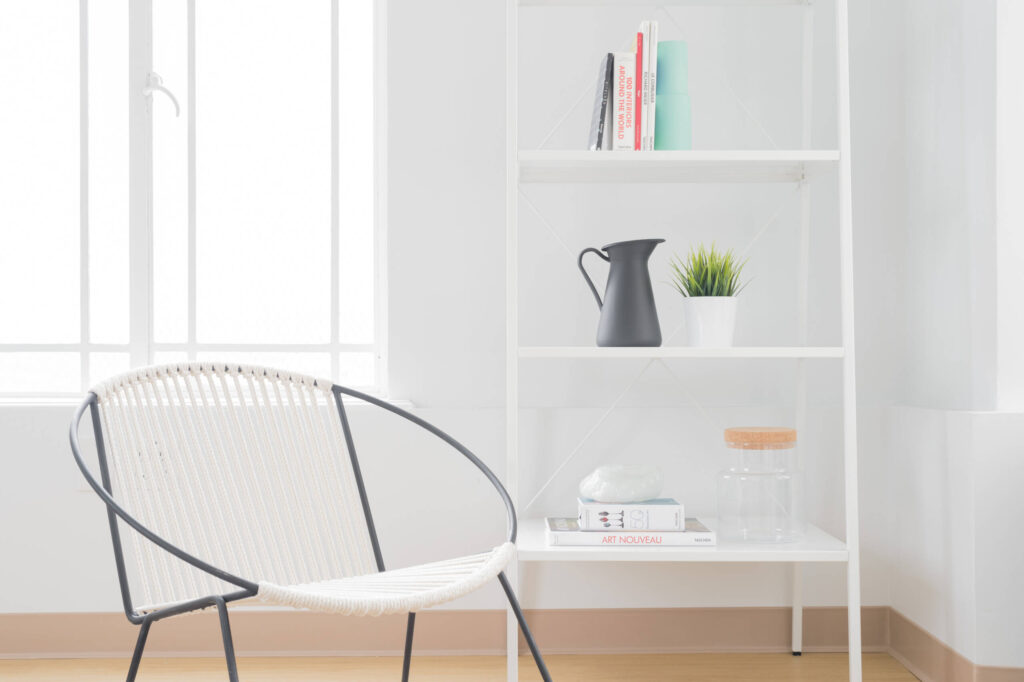 Minimalist chair and bookshelf arrangement.