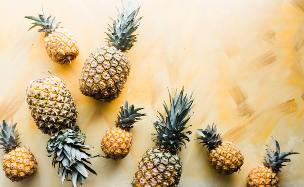 Arrangement of fresh pineapples on surface.