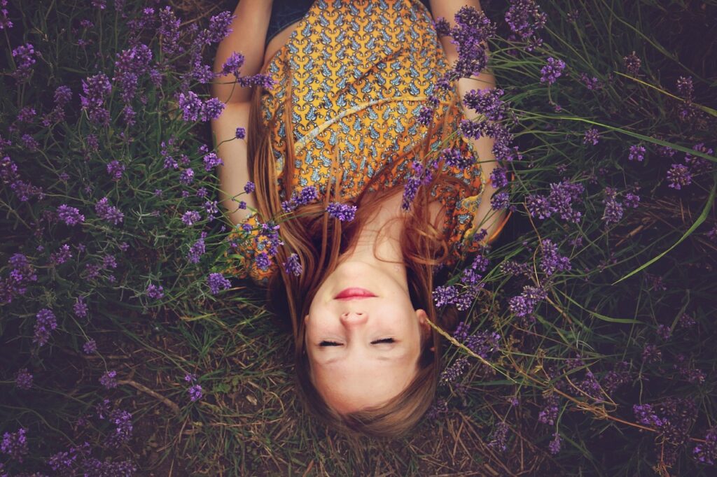 Lying in lavender field, serene moment.