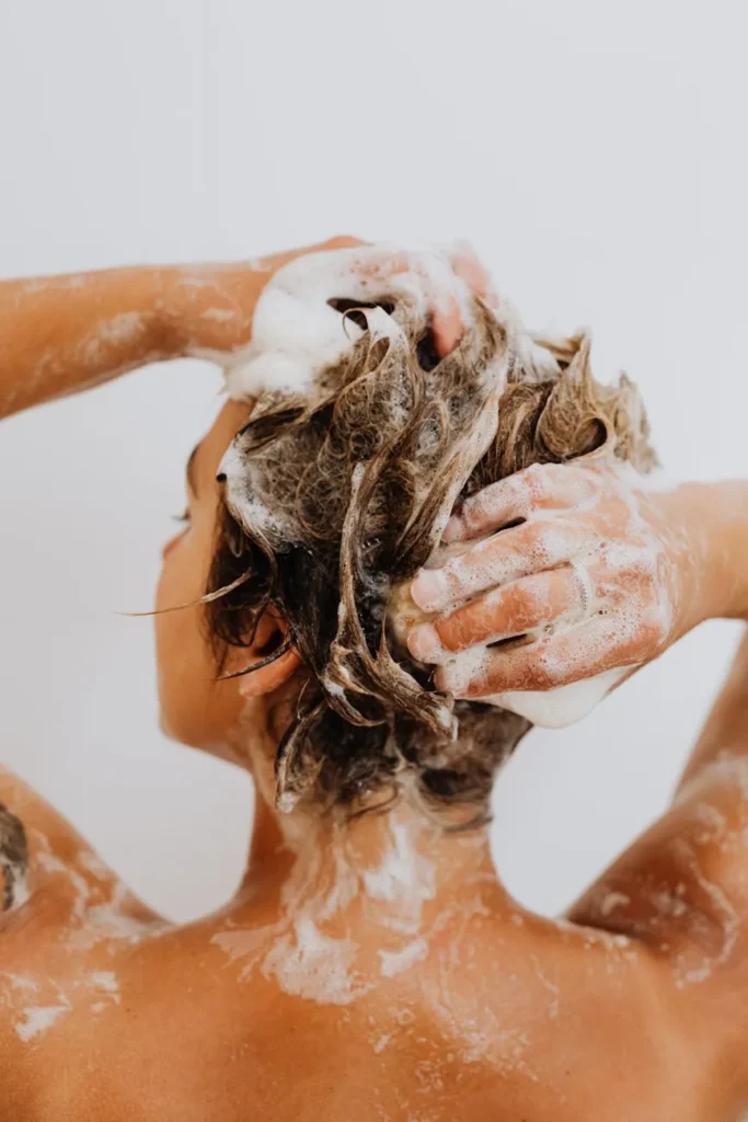 Person washing hair with shampoo