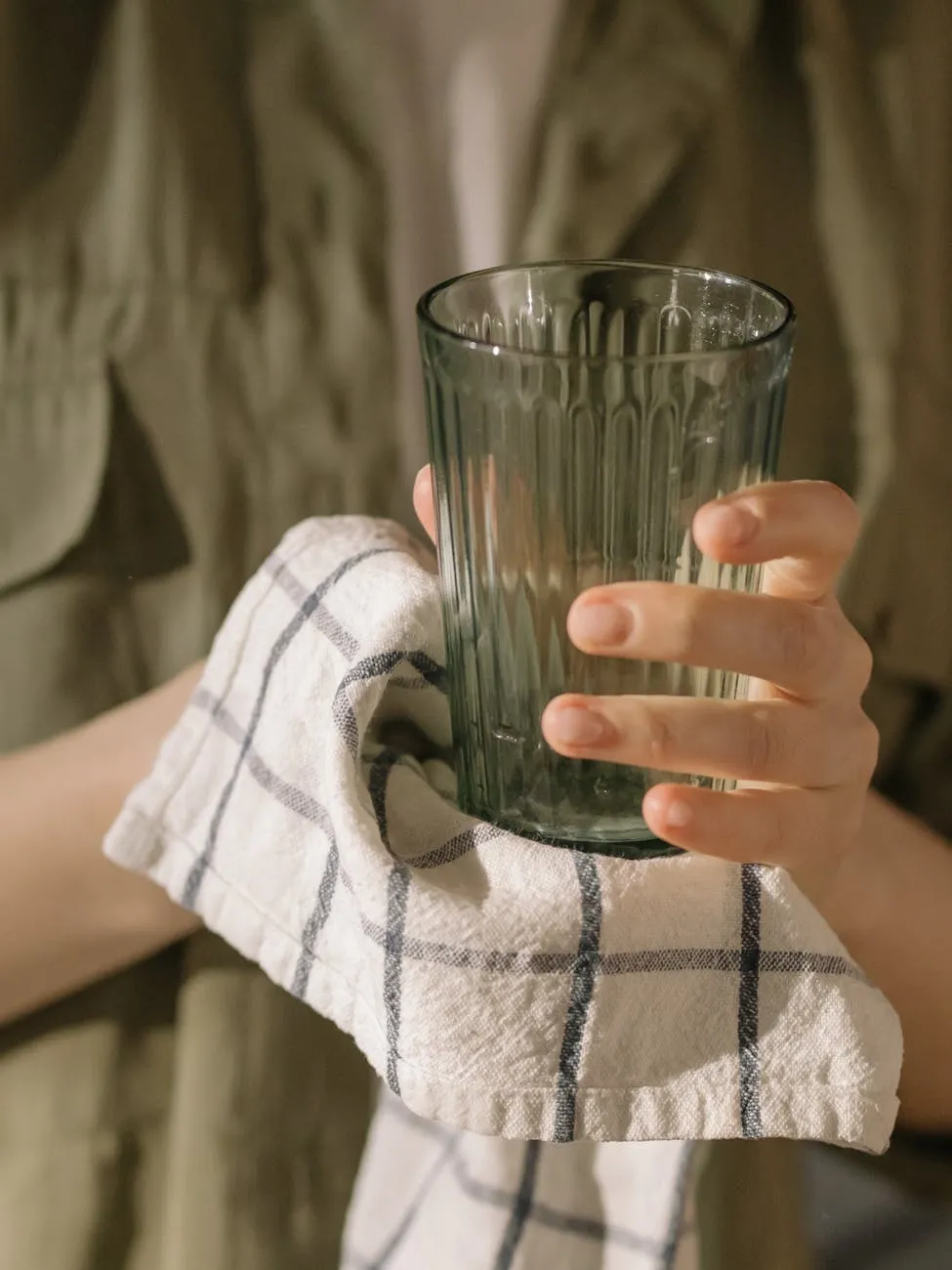 Person holding glass with towel.