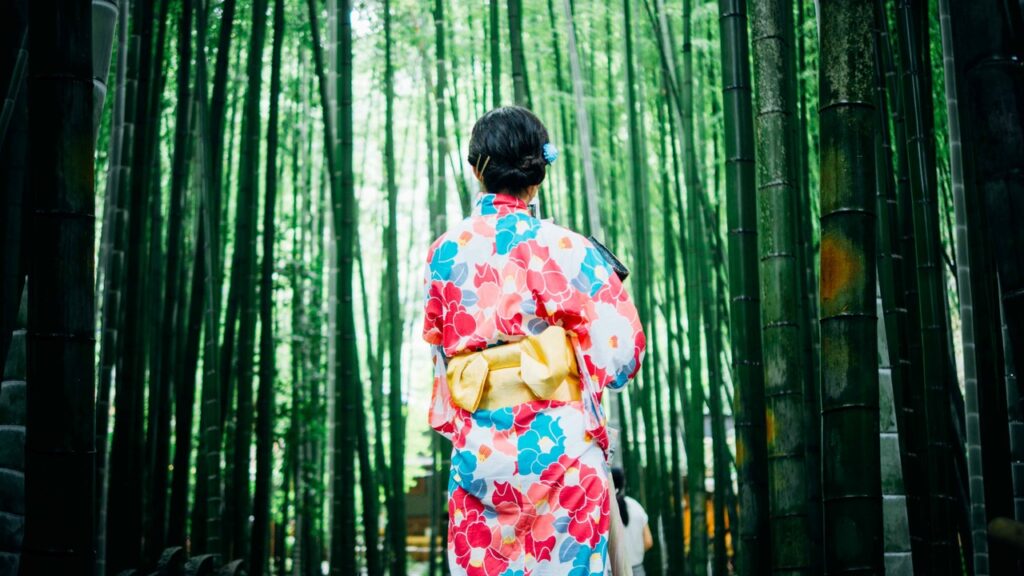 Woman in kimono among bamboo trees