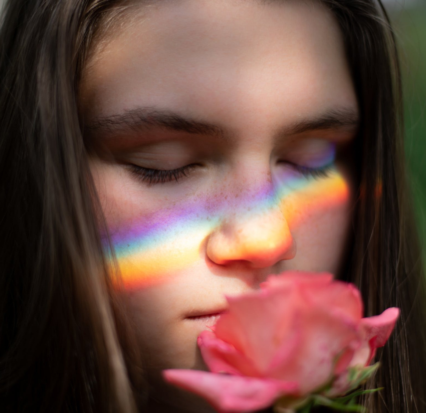 Girl holding and smelling a flower.