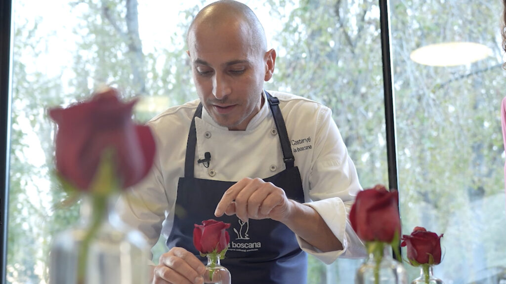Chef from La Boscana arranging red roses elegantly.