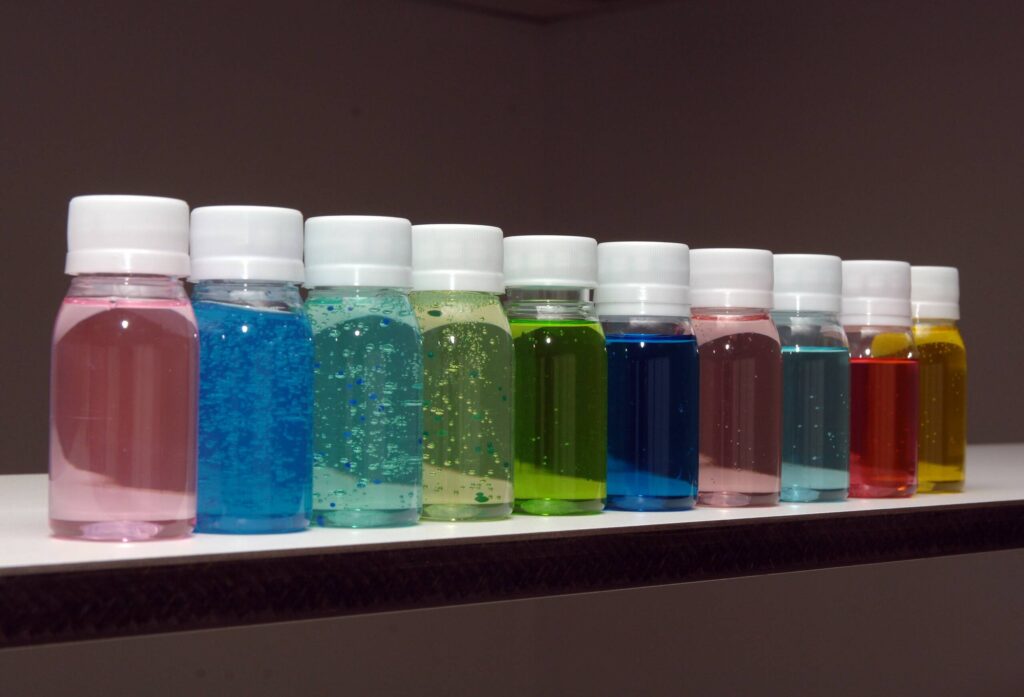 Colourful bottles of fragrance sent samples on shelf